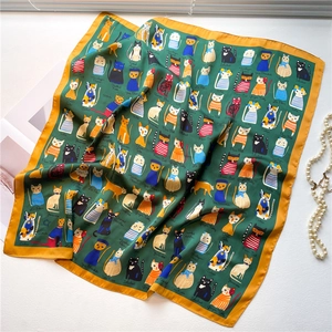 Detail of forest green silk scarf with hand-painted cat illustrations and yellow borders
