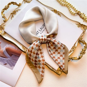 Close-up of heart-patterned silk scarf on a gold vintage tray with pearls