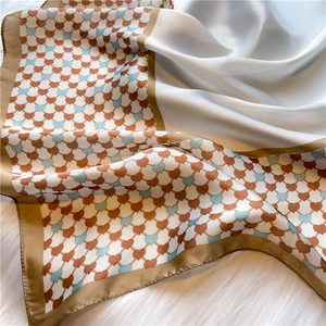 Close-up of heart pattern satin scarf with brown borders and light blue diamond grid