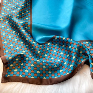 Close-up of heart pattern silk scarf with polished texture on white plush background