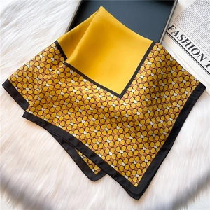 Detailed view of yellow square silk scarf with black borders and heart print patterns