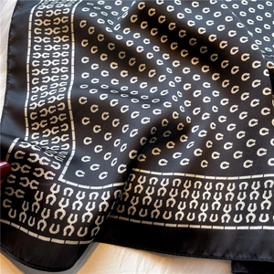 Detail eines schwarzen Seidenschals mit Hufeisenmuster und feinen Rollsaumkanten