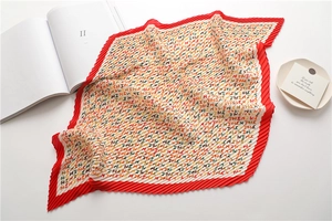 Detail of pleated silk scarf featuring letter H pattern and contrast red accordion edges