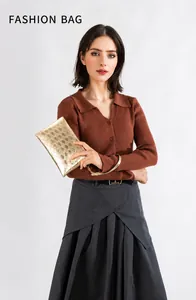 Détail d'une pochette dorée matelassée avec motif en losange et une dragonne raffinée