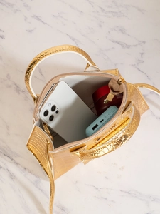 Innenansicht der goldenen Umhängetasche mit Krokoprägung zeigt Platz für Handy und Make-up