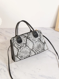 Detailansicht der Handtasche mit Krokodilledermuster und elegantem goldfarbenem Metallreißverschluss