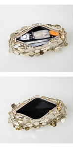 Gros plan de l'intérieur d'une pochette à paillettes dorées avec doublure noire et objets