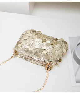 Détail du sac bandoulière à paillettes dorées avec chaîne et finition métallique