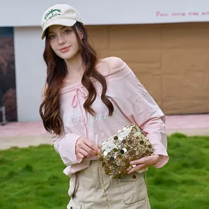 Sac à main chic à paillettes dorées assorti à un haut rose à épaules dénudées