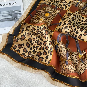 Detailed pattern of leopard print scarf with golden chains on textured background