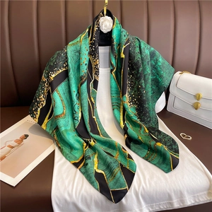 Macro detail of emerald marble pattern silk scarf with golden flowing lines on fabric