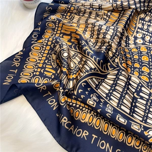Ethnic style navy silk scarf with orange geometric print and lettering on faux fur background