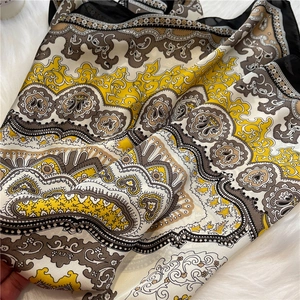 Close-up of Baroque paisley silk scarf with vivid patterns on soft white plush background