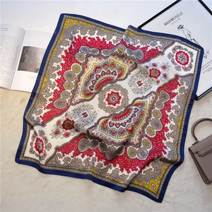 Close-up of bohemian silk scarf with paisley floral pattern on a soft beige carpet