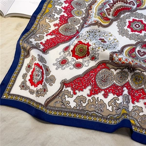 Detail of luxury paisley pattern silk scarf with elegant navy blue and red floral design
