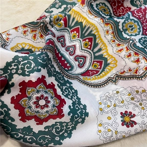Detailed close-up of Bohemian printed silk scarf with elegant green and red pattern details