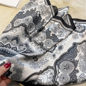 Detail of paisley print silk scarf in black and white showing smooth fabric texture