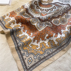 Detailed view of paisley silk scarf with vintage prints on white faux fur background