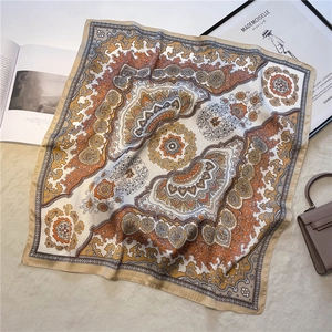Detail view of a luxury bohemian paisley silk-like square scarf with elegant satin edges