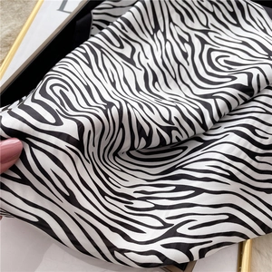 Detail shot of smooth black and white zebra print satin scarf with elegant silk texture