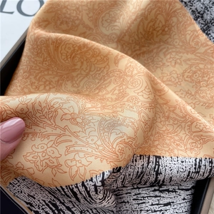 Detail of soft paisley silk scarf texture with yellow floral print and zebra edge