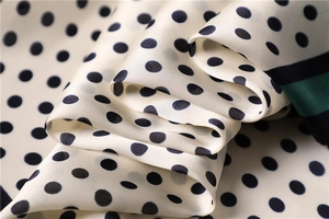 Macro shot of silk square scarf featuring navy polka dots and striped satin texture