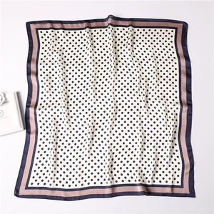 Detailed view of square silk scarf with classic polka dot pattern and tricolor border