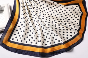 Detail of silk-satin square scarf with polka dots and mustard yellow contrast borders