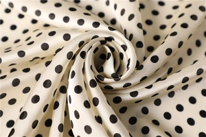 Detailed view of luxury polka dot silk scarf fabric with elegant soft sheen