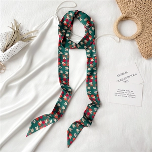 Détail d'un foulard étroit à imprimé géométrique porté sur une robe en satin blanc