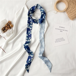 Détail d'un foulard étroit à fleurs sur robe avec imprimé double face en satin