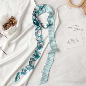 Détail d'un foulard en soie à fleurs et damier noué sur une robe en satin blanc