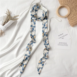 Mise à plat d'un foulard en soie bleue fleurie associé à une robe nuisette en satin blanc