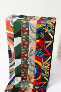 Detailed view of various printed twilly silk scarves with equestrian and geometric patterns