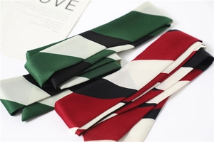 Close-up of elegant geometric color-block silk scarves in green and red patterns