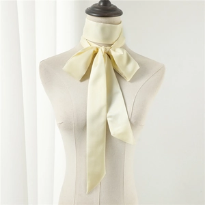 Detail of a beige silk narrow scarf tied into a bow on a mannequin neck with satin finish