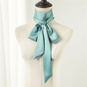 Detailed view of 100% silk sage green long scarf tied in a bow on a mannequin neck