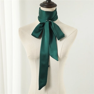 Close-up of dark green satin skinny scarf tied in a bow on a beige mannequin neck