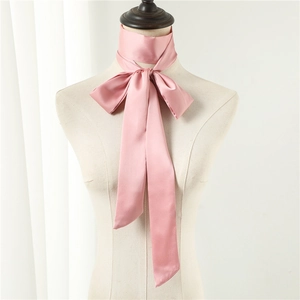 Detail of light pink satin skinny scarf tied as a bow on a mannequin neck