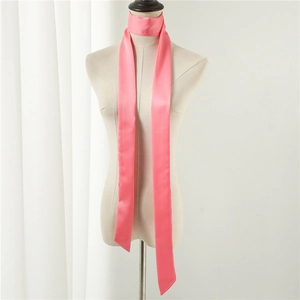 Macro detail of a bright pink skinny satin scarf with a smooth and glossy texture
