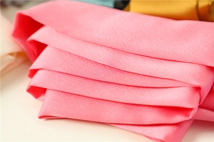 Macro shot of the soft pink satin fabric detail showing fine texture and silky finish