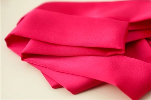 Detailed macro view of the rose red satin texture and silky fabric finish of the hair scarf