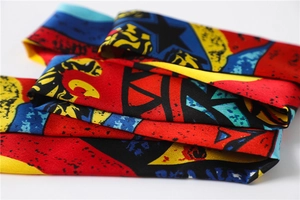 Macro detail of high-contrast geometric printed silk scarf with vibrant colorful patterns