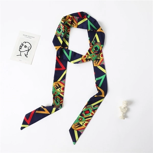 Artistic detail of geometric print narrow silk scarf styled with aesthetic props