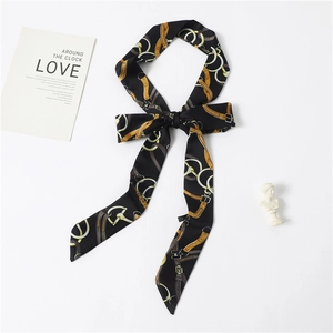 Detail of a black twilly scarf with vintage gold equestrian chain and buckle print