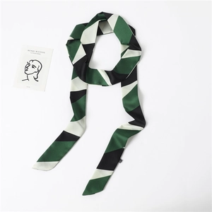 Detailed view of long narrow scarf with green and black geometric striped patterns