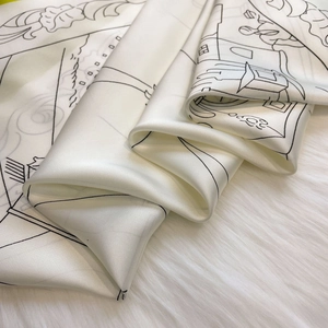 Detail eines Seidenschals mit schwarzem Liniendruck auf weißem Satin über Plüschstoff