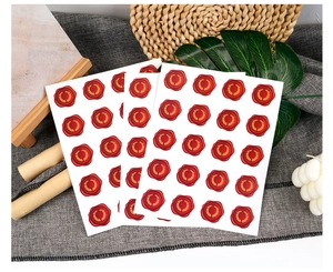 Dettaglio di sigilli in cera rossa vintage con eleganti motivi a ghirlanda di ulivo dorata.