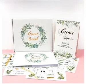 Close-up of elegant wedding guest book set with gold foil lettering and floral stickers