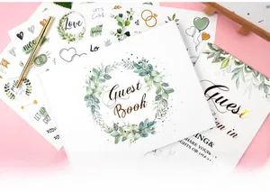 Detailed close-up of wedding guest book with gold foil lettering and gold signature pen set